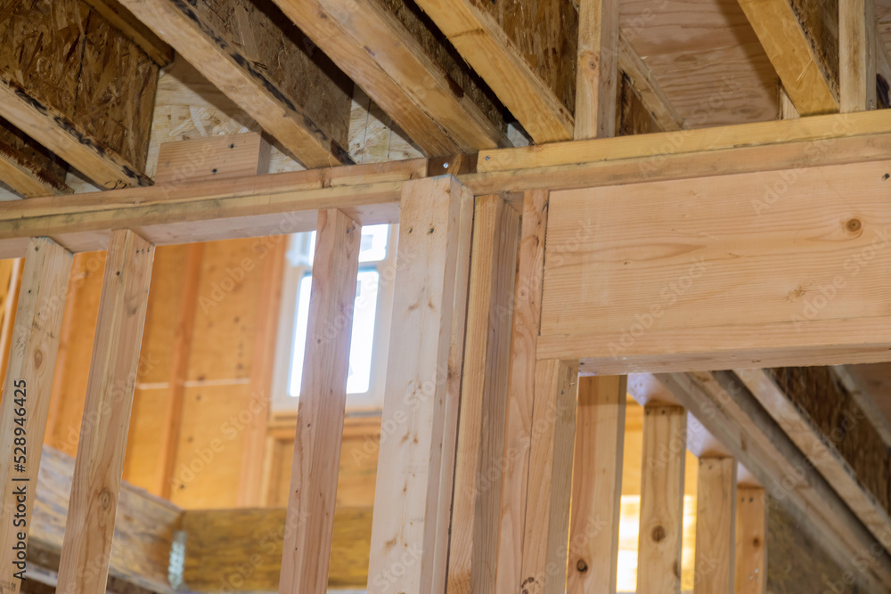 Wood framing beams stick framing building of new house under construction on built home