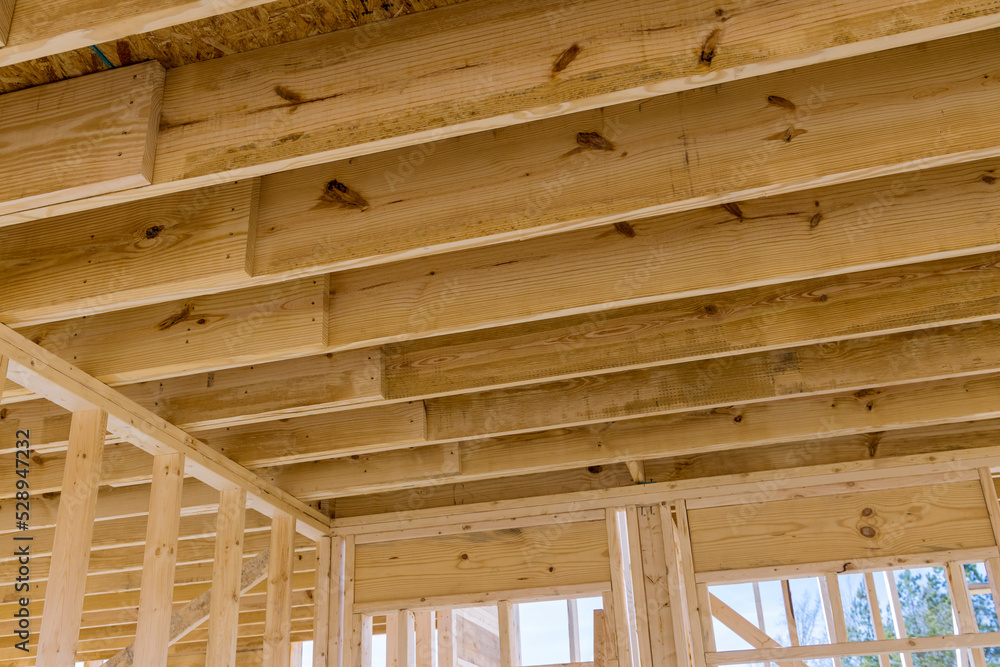 The wooden beams sticks that being used to build a new house are being installed The wooden beams sticks that being used to build a new house are being installed