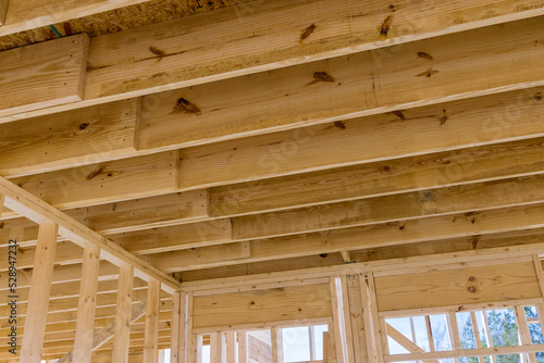 The wooden beams sticks that being used to build a new house are being installed © ungvar