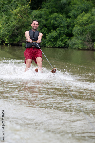 Young man waterskiing on the river on a beautiful summer day