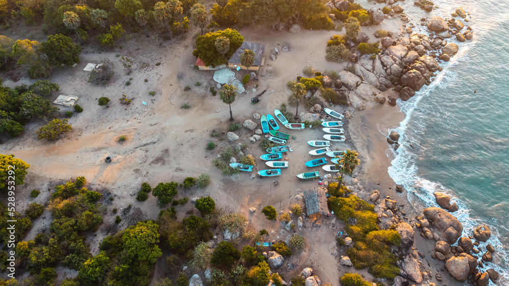 Ocean tropical landscape, rocky coast with fishing boats, drone shot, water and beach.