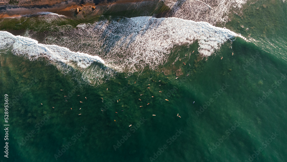 Beautiful view of the sea and the ocean with surfers waiting for the waves.