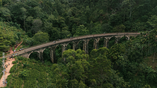 9 Arch Railway Bridge, Ella in Sri Lanka, a historic building set against a green tropical jungle background.