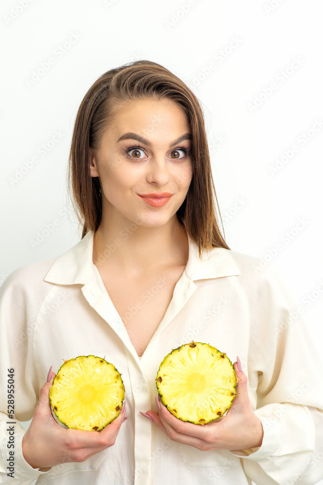 Young Caucasian smiling woman holding slices pineapple over white background, breast health concept Young Caucasian smiling woman holding slices pineapple over white background, breast health concept