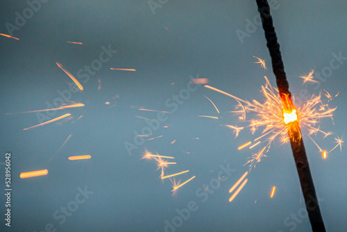 Bengal lights with sparks on the background of the sea