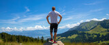 hiker man on mountain peak enjoying panoramic landscape view