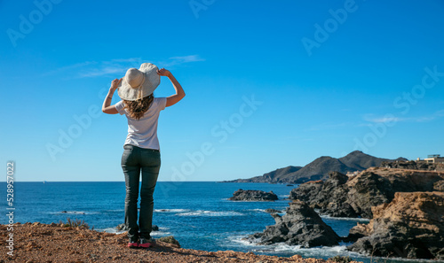 woman looking at seacoast and blue sky