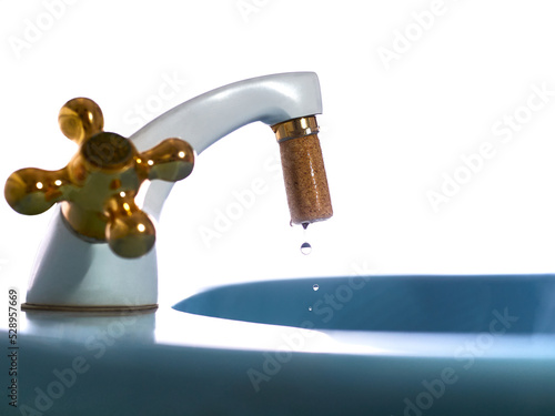 Side close-up of a faucet with wet cork stopper economizing water in times of drought