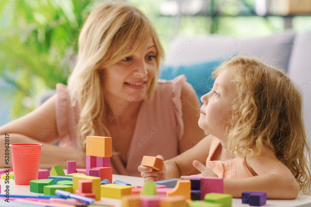 Fototapeta premium Happy girl playing at home with her mother