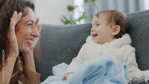 Family, mother and baby being funny with game, crazy together and comic with smile in living room in home. Love, care and happiness while playing peekaboo with young and happy child and mom at house