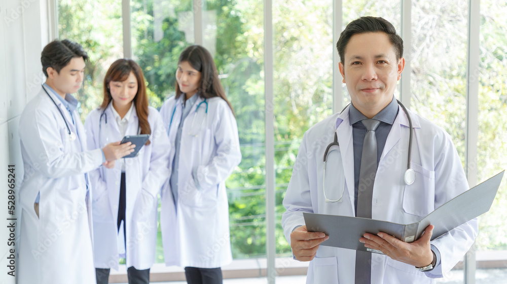 Medicine and healthcare concept : happy and cheerful senior asian doctors standing and posing thump up, Young Male and Female doctor in lobby of hospital on background. Medicine and healthcare concept : happy and cheerful senior asian doctors standing and posing thump up, Young Male and Female doctor in lobby of hospital on background.
