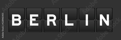 Black color analog flip board with word berlin on gray background