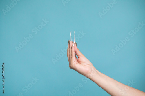Female hand holding lens tweezers