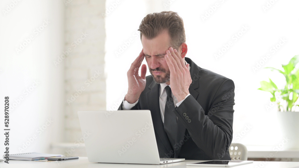 Young Businessman having Headache while Working on Laptop Young Businessman having Headache while Working on Laptop