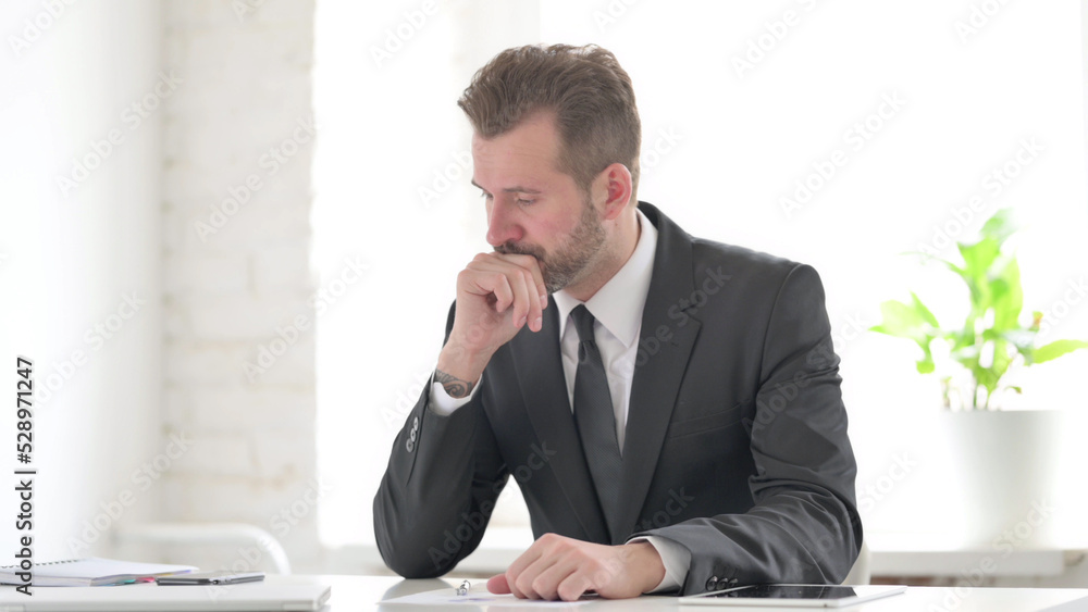 Naklejka premium Young Businessman Upset while Reading Documents in Office