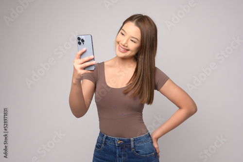 Young asian woman using smartphone over white background, technology concept. ..