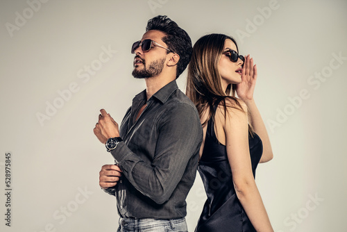 Fashion photo of handsome young couple posing in sunglasses. Personal accessories.
