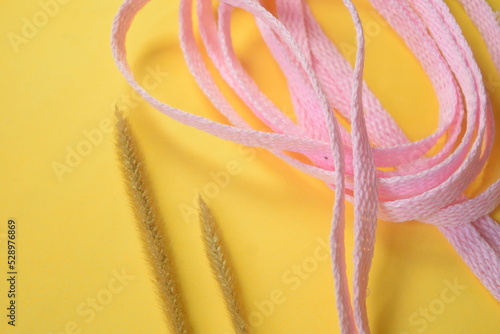 pink shoelace on yellow background