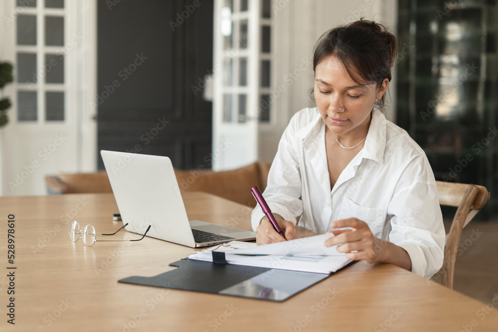 Routine work in the office, an economist employee of the company makes an online report in the table. Routine work in the office, an economist employee of the company makes an online report in the table.