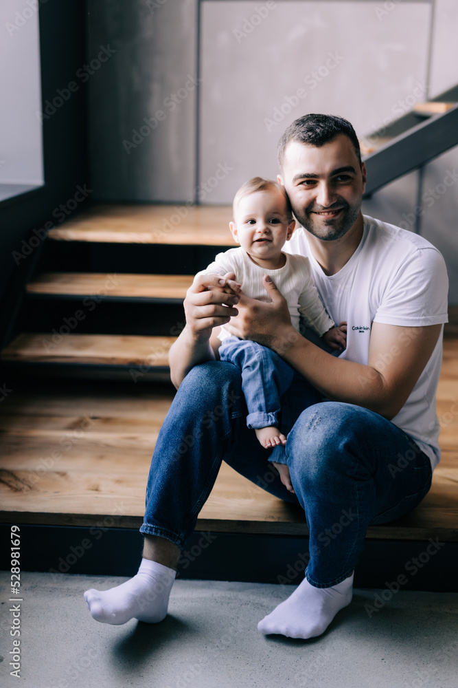 Happy father lying on sofa holding baby woman playing, smiling. Side view. Happy father lying on sofa holding baby woman playing, smiling. Side view.