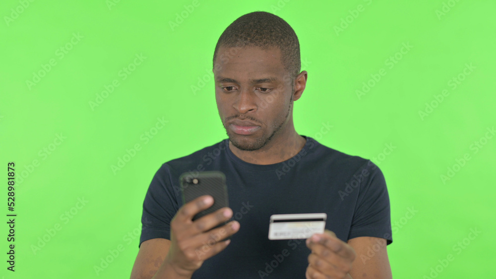 Online Shopping on Smartphone by African Man on Green Background Online Shopping on Smartphone by African Man on Green Background
