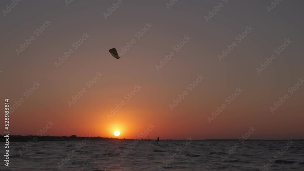 Man on the kiteboard rides in the evening Man on the kiteboard rides in the evening
