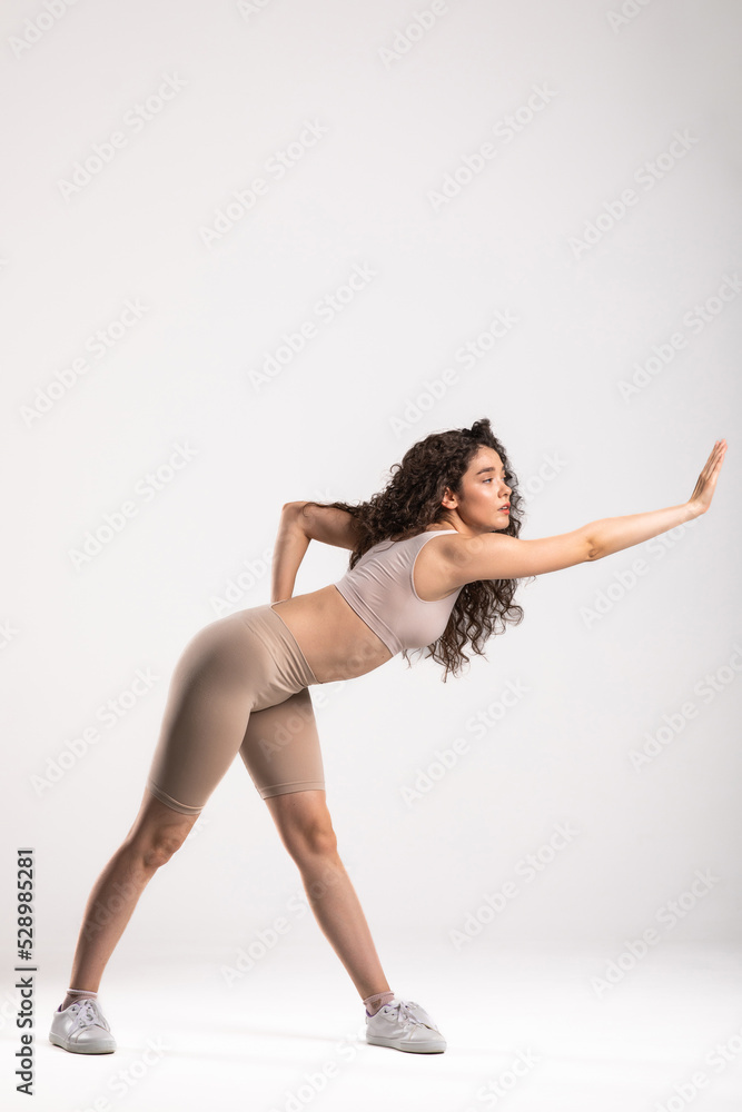 Fototapeta premium Sporty young woman training against white background