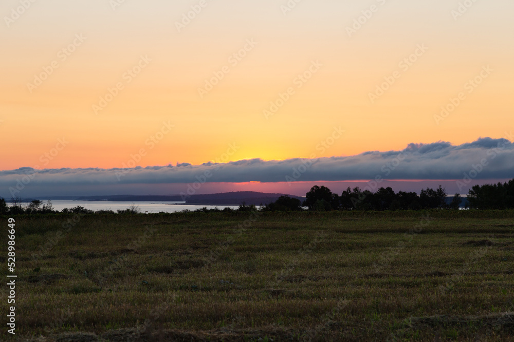 Series of small islands in the St. Lawrence River seen at sunrise from Saint-François village in the Island of Orleans during a late summer sunrise, Quebec, Canada