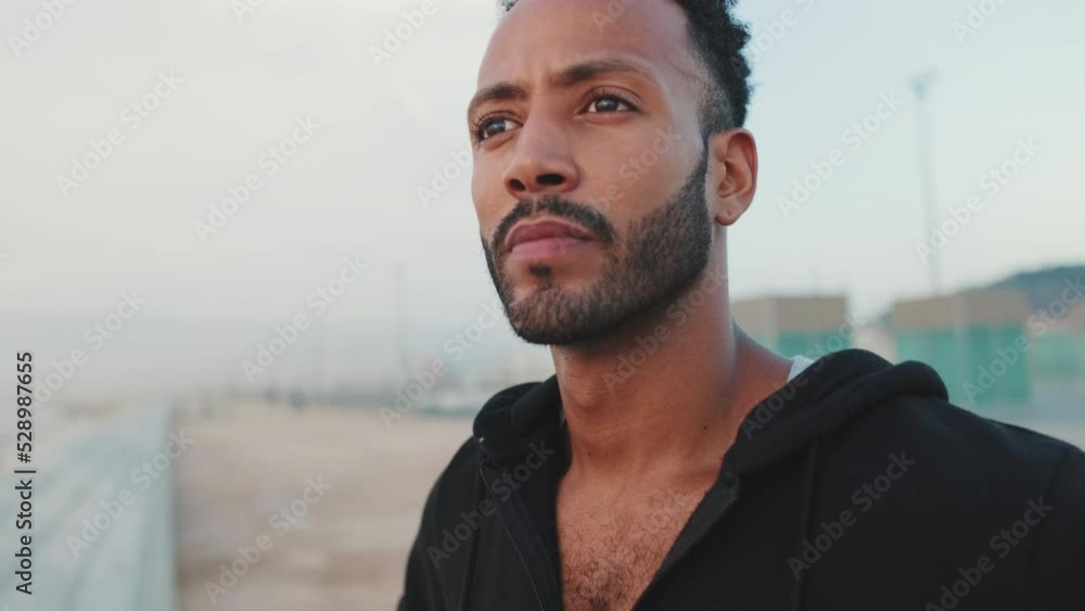 Close-up of bearded male athlete standing on the embankment looking at the sea Close-up of bearded male athlete standing on the embankment looking at the sea