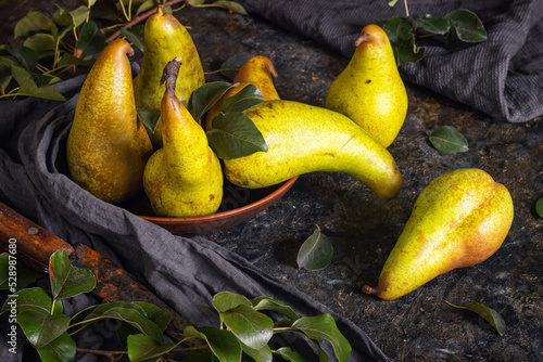 Tablou pe pânză Rural still life, low key dark photography - view of a Conference pear in clay d