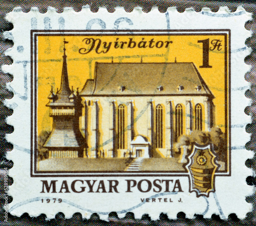 Cairo, Egypt, August 15 2022: Old used Hungarian Magyar posta stamp 1979 features nyirbator Nyírbátor cityscape  in Hungary, selective focus of vintage retro stamp of a building, 1Ft photo