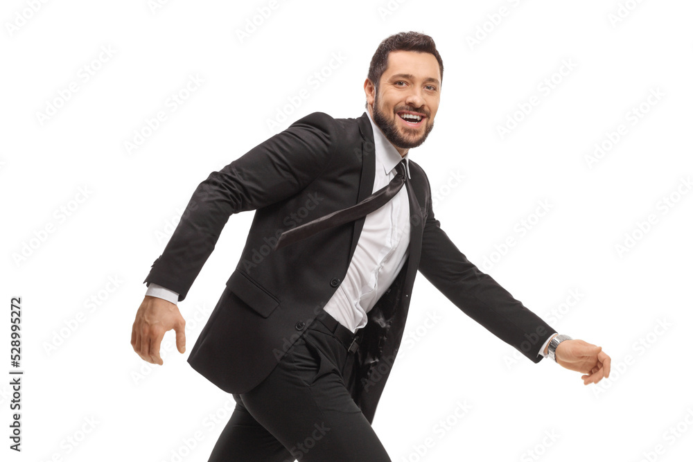 Handsome cheerful man in a black suit running and looking at camera Handsome cheerful man in a black suit running and looking at camera