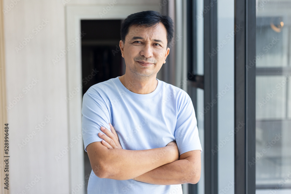 Smiling asian man looking happy at camera, cross arms chest confident in the office Smiling asian man looking happy at camera, cross arms chest confident in the office
