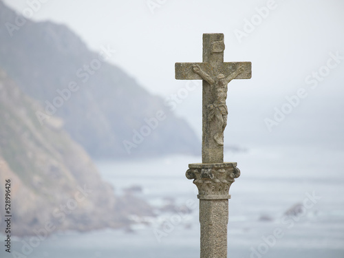 Stone cross with sea and cliffs in the background photo