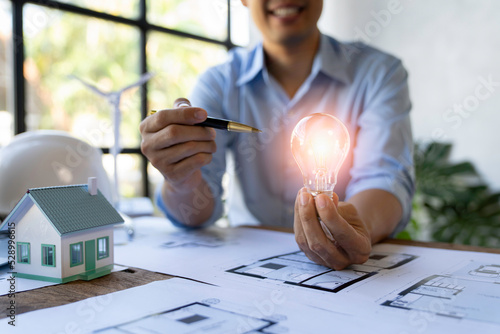 Fotografie Light blub on businessman or  Architect and engineer hands
