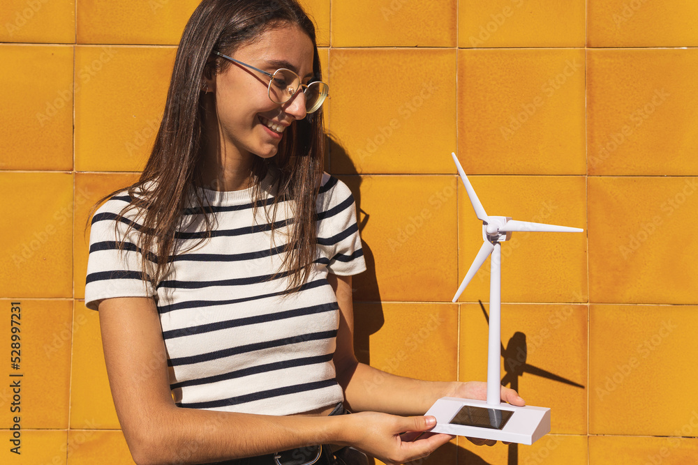 Young lady hold small solar powered windmill in countryside Young lady hold small solar powered windmill in countryside