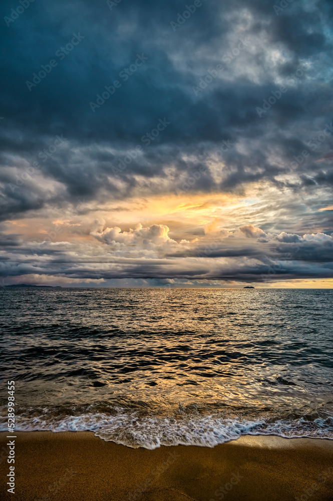 Stormy tropical skies at a beach near Pattaya, Thailand during the monsoon rainy season can produce spectacular sunsets