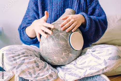 woman in her home playing the udu drum, meditating photo