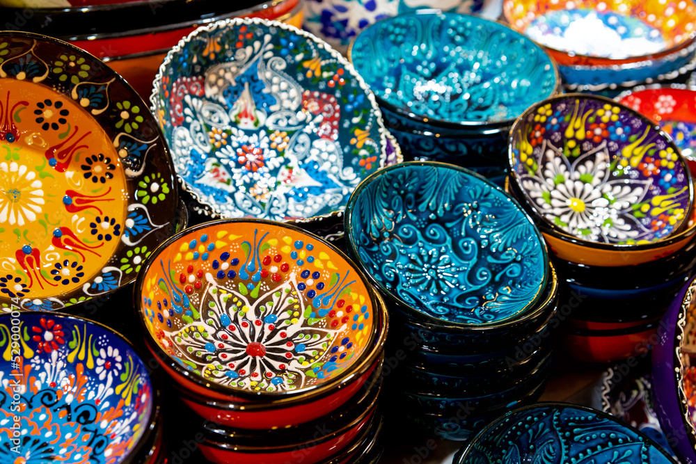 Stack of classical traditional Turkish ceramics, handmade colorful dishes at the Istanbul Grand Bazaar. Istanbul, Turkey souvenirs. Selected focus, copy space