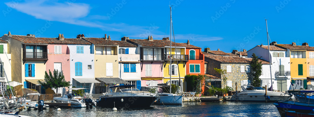 A view of Port Grimaud, provencal and mediterranean village on the French Riviera, in Provence-Alpes-Côte d'Azur, Var, south of France during a sunny summer day with a blue sky in the background