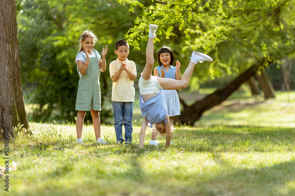 Fototapeta premium Group of asian and caucasian kids having fun in the park