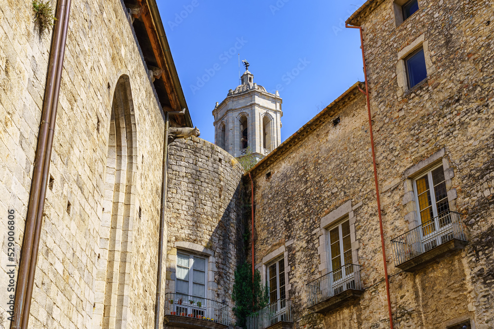 Old stone houses and cathedral tower emerging above the roofs, Gerona, Spain.