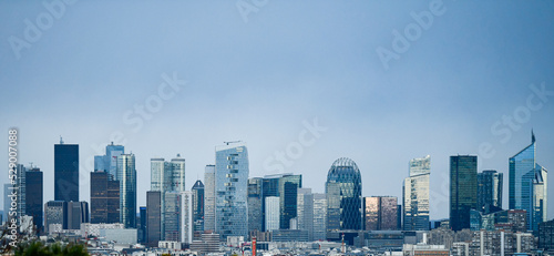 Panoramic view of the skyline of the financial district of La Défense, Paris, France (day time) with a blue sky in the background