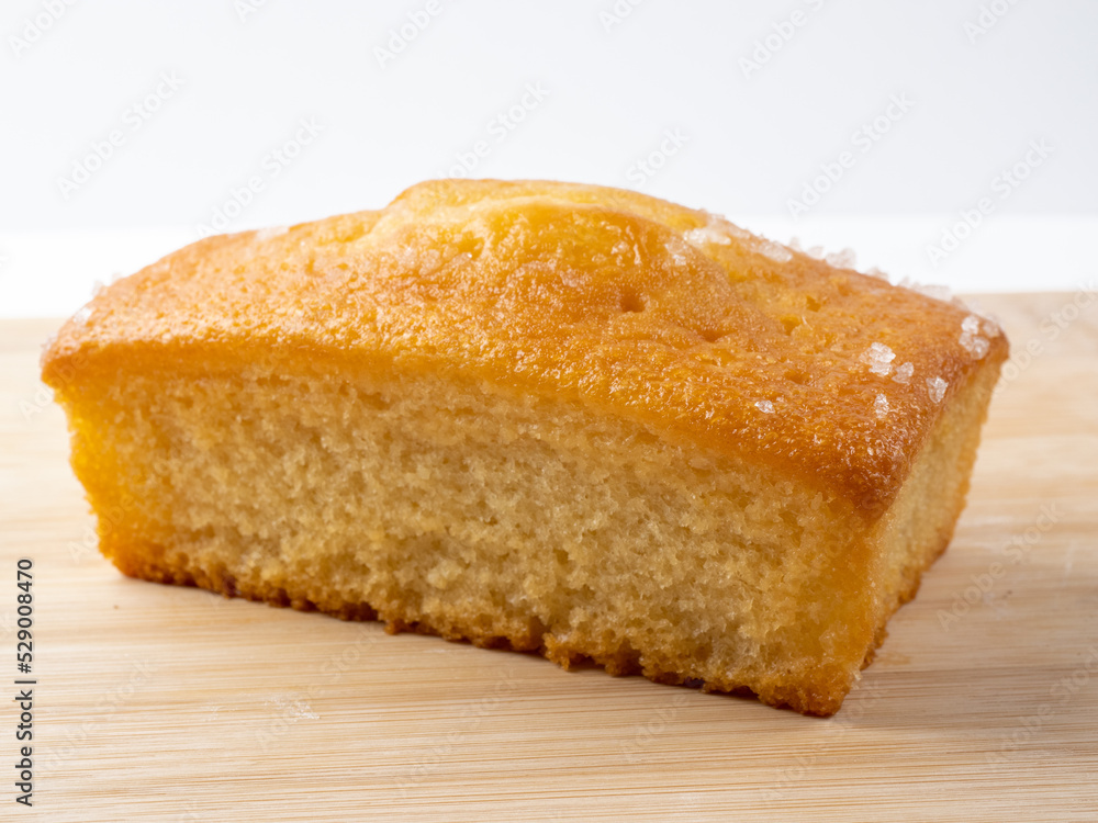 Lemon drizzle loaf tin cake isolated on a bamboo board Lemon drizzle loaf tin cake isolated on a bamboo board
