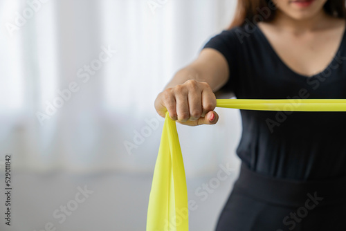 Physical therapist gives resistance band exercises. About the arms and shoulders of male office workers  office syndrome  male patient. Physiotherapy concept.