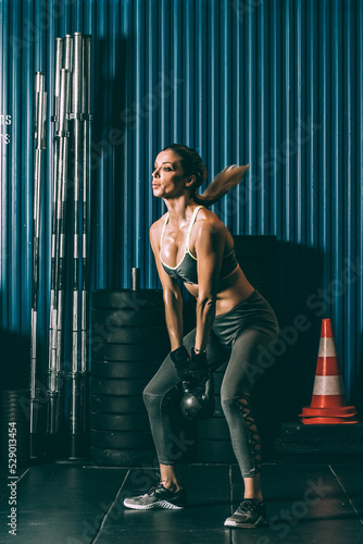 Fit woman training working out lifting kettlebell in Gym