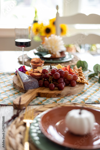Charcuterie board on a dining room table styled for fall
