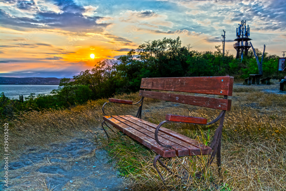 Wooden bench and sunset panorama of Balaton