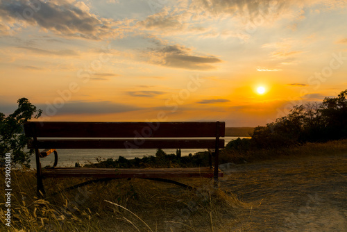 Wooden bench and sunset panorama of Balaton