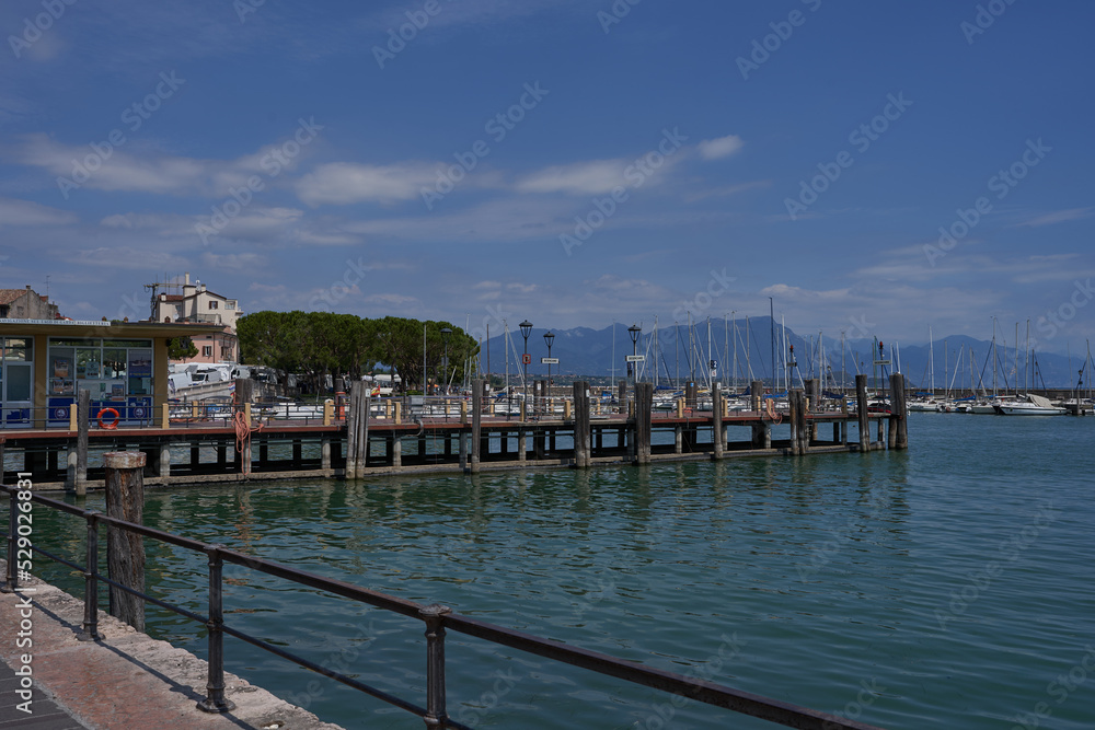 Desenzano del Garda, Italy - July 12, 2022 - yachts and boats docked at the port on Lake Garda on a sunny summer morning